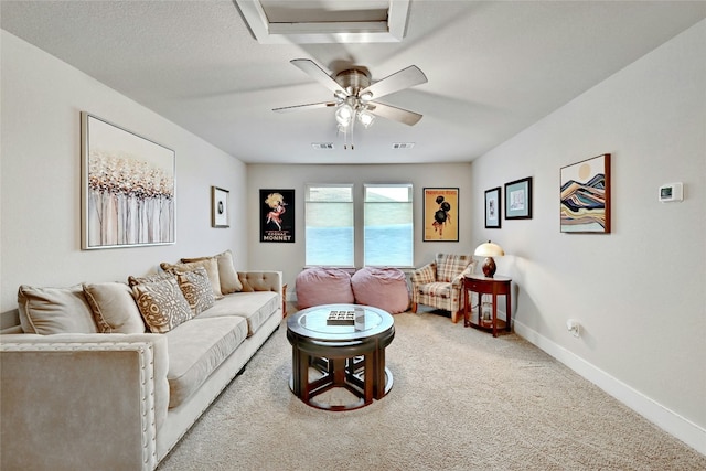 living room featuring a textured ceiling, ceiling fan, and carpet