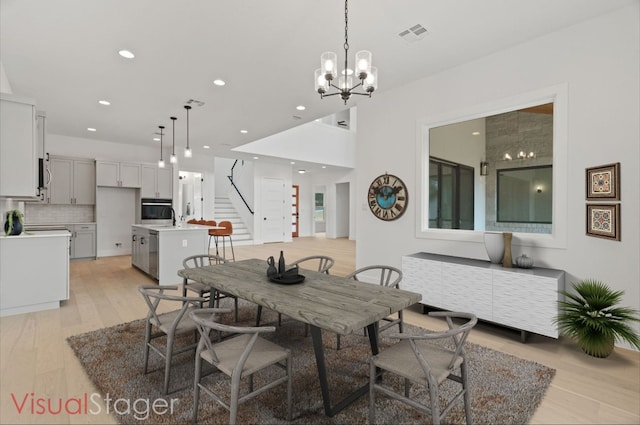 dining area with an inviting chandelier and light wood-type flooring