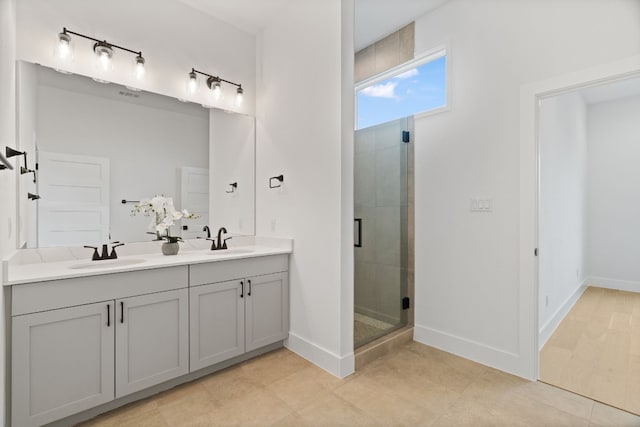 bathroom featuring a shower with door and vanity