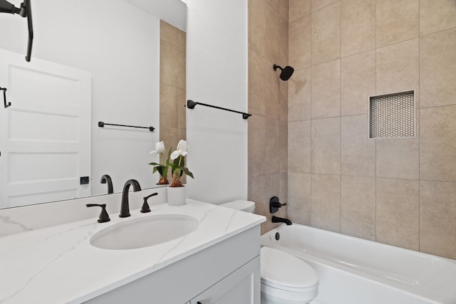 full bathroom featuring vanity, tiled shower / bath combo, and toilet