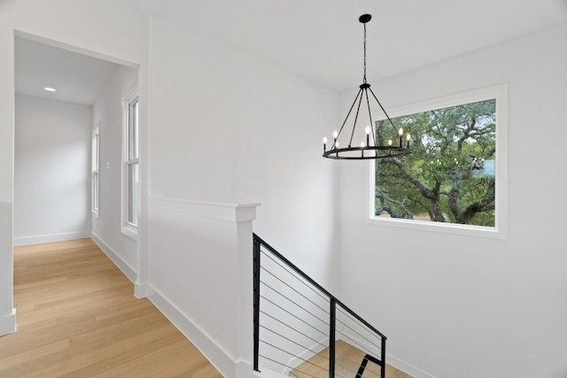 staircase featuring an inviting chandelier and hardwood / wood-style flooring