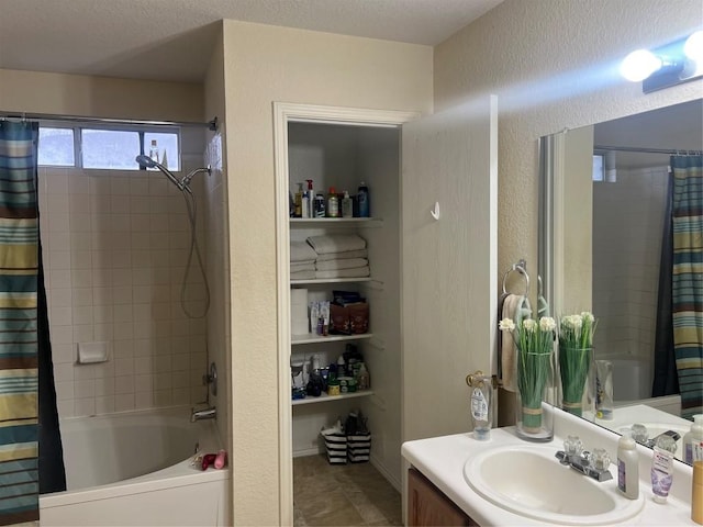 bathroom featuring vanity, shower / bathtub combination with curtain, and a textured ceiling