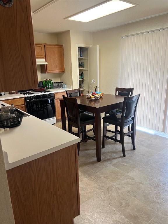 kitchen with white range with gas cooktop, kitchen peninsula, and sink