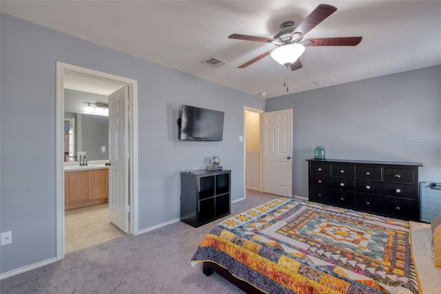 bedroom featuring light carpet, sink, ceiling fan, and ensuite bathroom