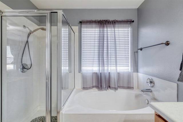 bathroom with a healthy amount of sunlight, plus walk in shower, and vanity