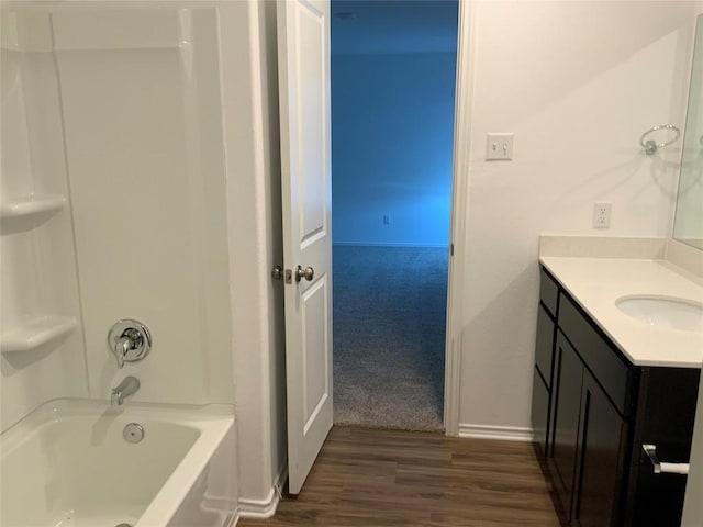 bathroom featuring shower / bath combination, wood finished floors, vanity, and baseboards