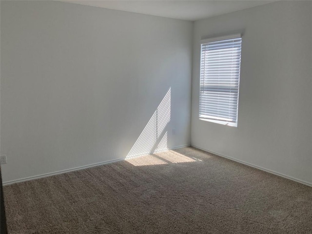 empty room with carpet, a healthy amount of sunlight, and baseboards