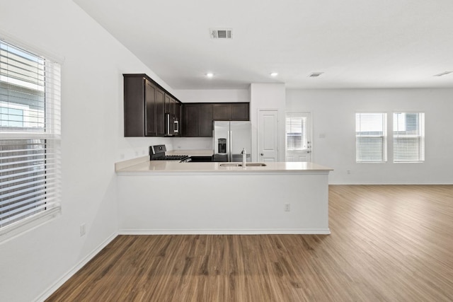 117 Citrine Crst, Maxwell, TX 78656 - kitchen featuring appliances with stainless steel finishes, wood finished floors, dark brown cabinets, light countertops, and a peninsula