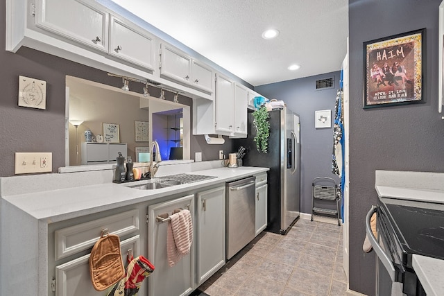 kitchen featuring sink, dishwasher, white cabinetry, range with electric cooktop, and light tile patterned flooring