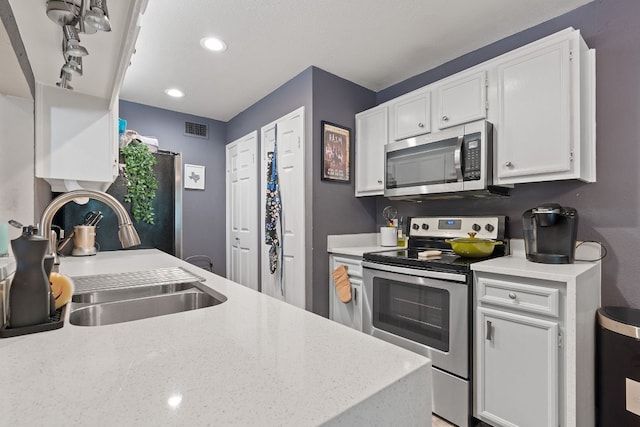 kitchen with sink, stainless steel appliances, and white cabinets