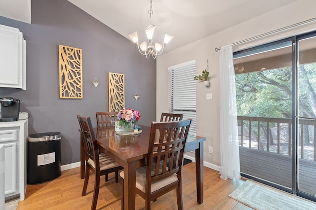 dining space featuring a notable chandelier, light hardwood / wood-style flooring, and vaulted ceiling