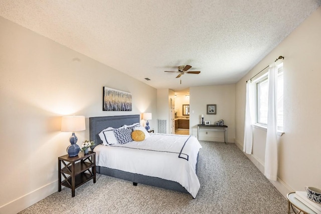 carpeted bedroom featuring ceiling fan, connected bathroom, and a textured ceiling