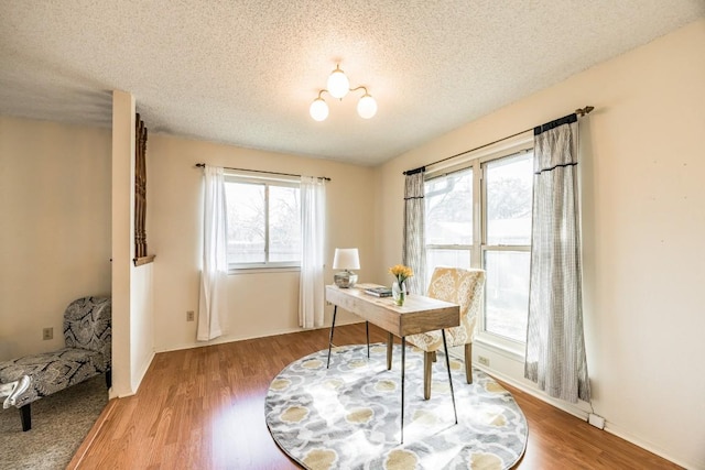 office with an inviting chandelier, hardwood / wood-style floors, and a textured ceiling