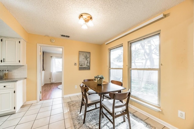 dining area featuring a textured ceiling and light tile patterned flooring