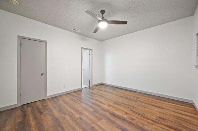 unfurnished bedroom with ceiling fan, dark wood-type flooring, and a textured ceiling