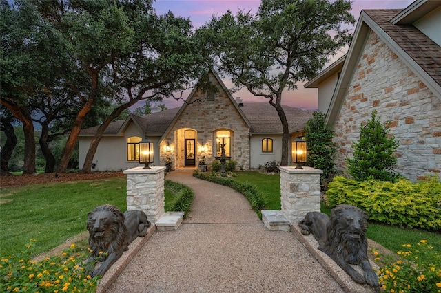 french country home featuring a lawn