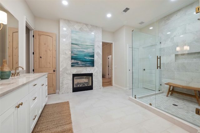 bathroom with an enclosed shower, vanity, and a large fireplace