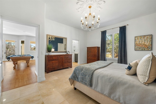 tiled bedroom with billiards, ensuite bath, multiple windows, and a notable chandelier