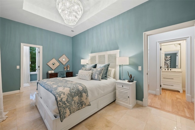 tiled bedroom featuring an inviting chandelier and a tray ceiling