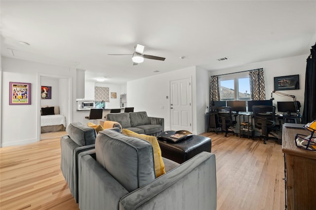 living room with ceiling fan and light wood-type flooring