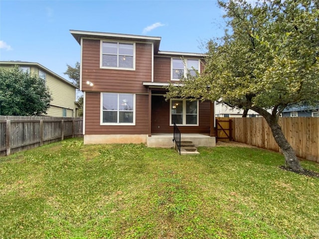 rear view of property featuring a lawn