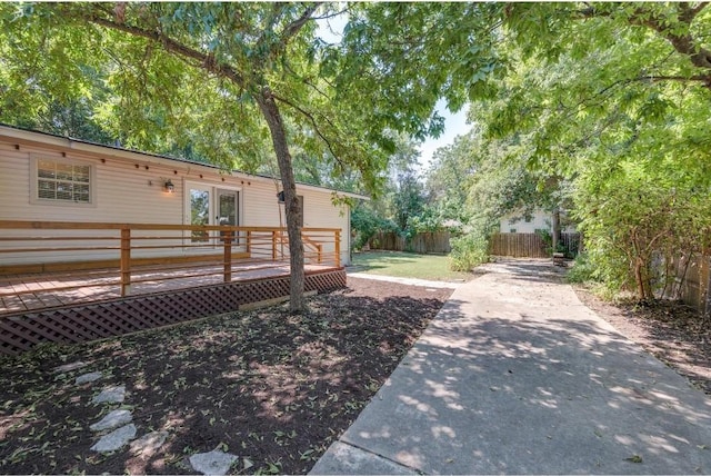 view of yard featuring a wooden deck and french doors