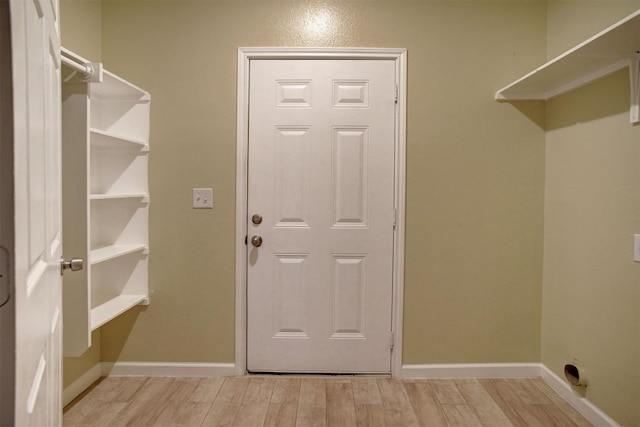 laundry area featuring electric dryer hookup and light hardwood / wood-style floors