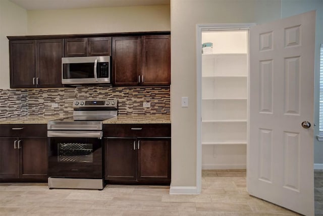 kitchen featuring appliances with stainless steel finishes, dark brown cabinets, and backsplash