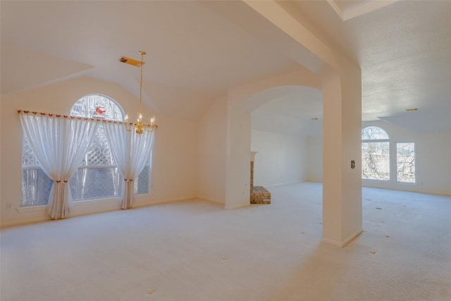 spare room featuring lofted ceiling, a chandelier, and carpet floors