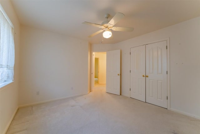 unfurnished bedroom featuring ceiling fan, light colored carpet, and a closet