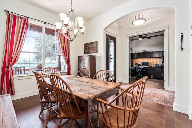 dining area featuring ceiling fan with notable chandelier