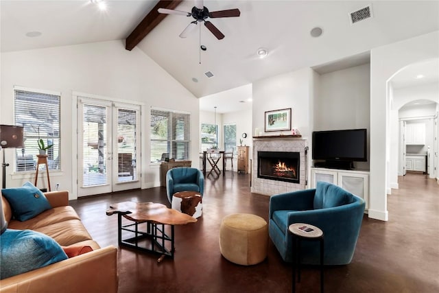 living room with beamed ceiling, ceiling fan, a fireplace, and high vaulted ceiling