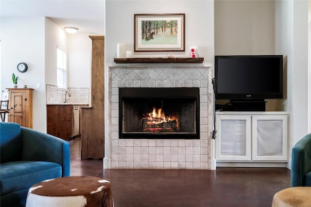 living room featuring a brick fireplace and sink