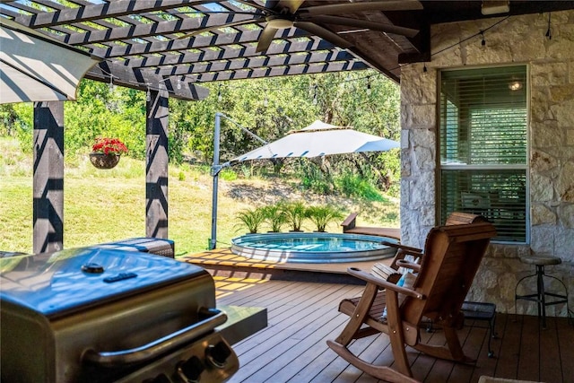 wooden terrace featuring an outdoor hot tub, a pergola, and a lawn