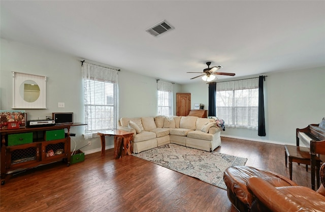 living room featuring dark wood-type flooring and ceiling fan