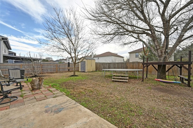 view of yard featuring a storage unit, a patio, a trampoline, and central air condition unit