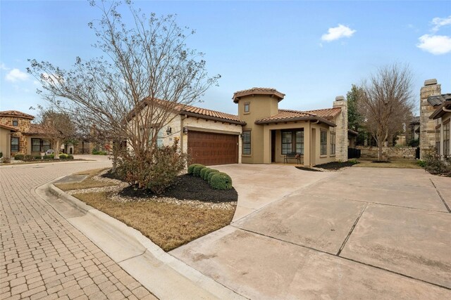 204 Delfino Cir, Lakeway, TX 78734 - mediterranean / spanish-style house with a garage, concrete driveway, a tile roof, and stucco siding