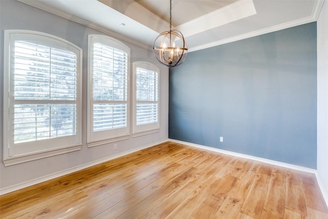 unfurnished room featuring hardwood / wood-style floors, crown molding, and a raised ceiling