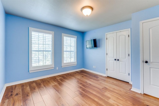 unfurnished bedroom featuring a closet and light wood-type flooring