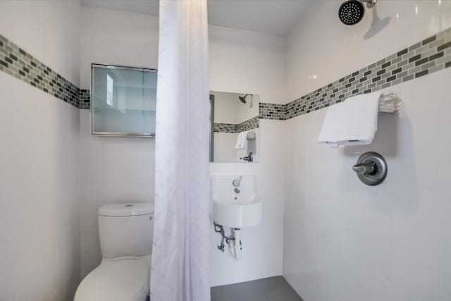 bathroom featuring a shower with curtain and toilet