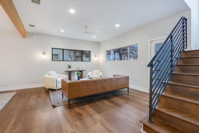 living room with beam ceiling, hardwood / wood-style flooring, and ceiling fan