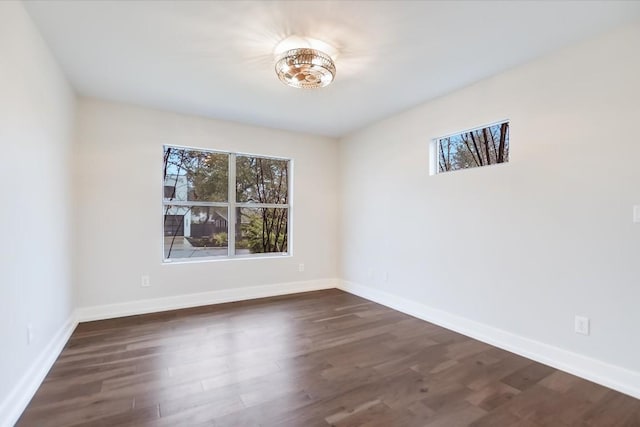 empty room with dark hardwood / wood-style flooring