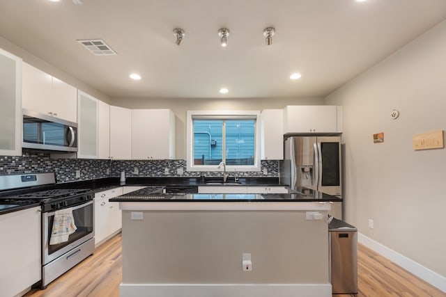 3301 Rockhurst Ln, Austin, TX 78723 - kitchen featuring stainless steel appliances, white cabinets, light wood-style flooring, a kitchen island, and recessed lighting