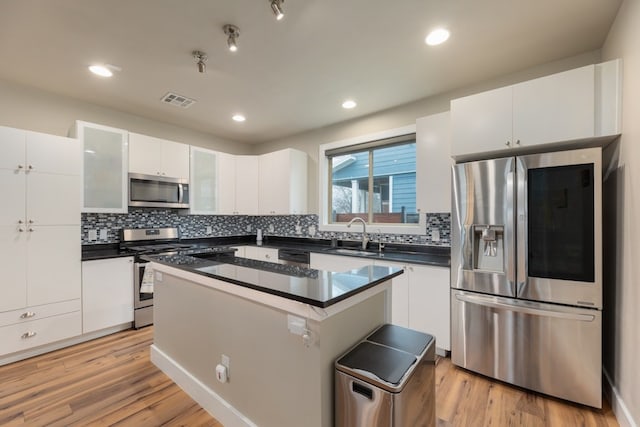 3301 Rockhurst Ln, Austin, TX 78723 - kitchen featuring stainless steel appliances, dark countertops, white cabinets, backsplash, and recessed lighting