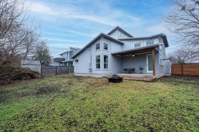 3301 Rockhurst Ln, Austin, TX 78723 - rear view of property featuring an outdoor fire pit, a fenced backyard, a patio area, ceiling fan, and board and batten siding
