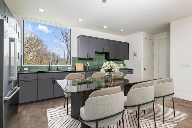 kitchen with sink, gray cabinets, high end refrigerator, and a center island