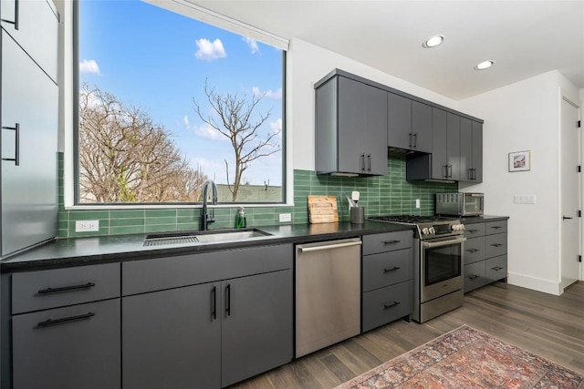 kitchen with dark hardwood / wood-style flooring, sink, gray cabinets, and appliances with stainless steel finishes