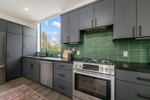 kitchen featuring sink, gray cabinets, stainless steel appliances, tasteful backsplash, and dark hardwood / wood-style flooring