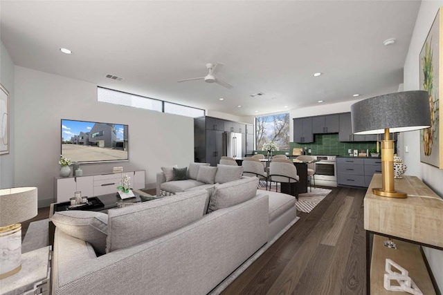 living room with ceiling fan and dark hardwood / wood-style flooring