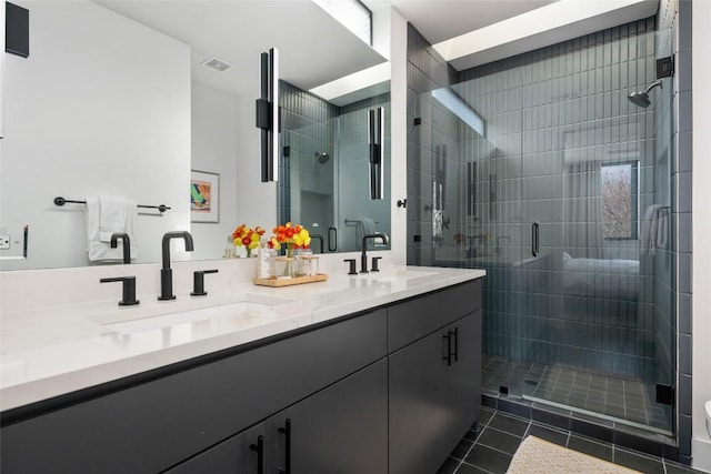 bathroom with tile patterned floors, vanity, and a shower with door